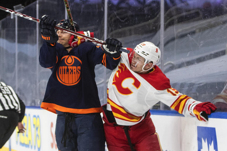 Edmonton Oilers' Alex Chiasson (39) checks Calgary Flames' Matthew Tkachuk (19) during the first period of an NHL hockey game, Thursday, April 29, 2021 in Edmonton, Alberta. (Jason Franson/Canadian Press via AP)