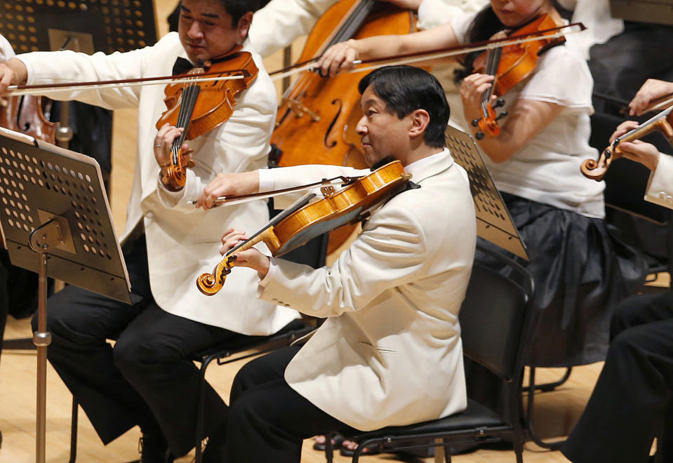 FILE - In this July 7, 2013, file photo, Japan's Crown Prince Naruhito, center, plays the viola during a concert of the Gakushuin university's alumni in Tokyo. Japan’s new emperor is a team player, musician and historian who will bring a global perspective to an ancient institution. (AP Photo/Shizuo Kambayashi, File)