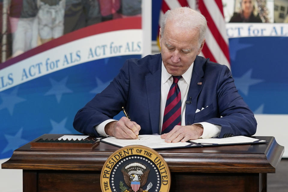 President Joe Biden signs the "Accelerating Access to Critical Therapies for ALS Act" into law during a ceremony in the South Court Auditorium on the White House campus in Washington, Thursday, Dec. 23, 2021. (AP Photo/Patrick Semansky)