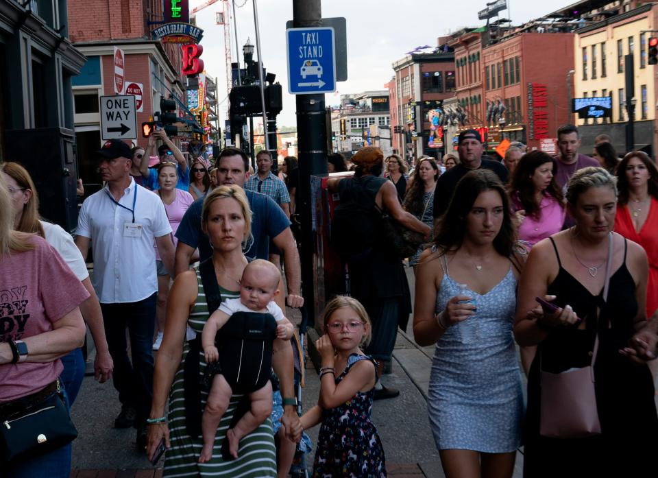 Julie Gatty of Memphis, Tenn., with baby, Aly, 9 months, and Jackie, 6, heads up Nashville's Lower Broadway on Thursday evening, July 13, 2023. She and her family, including husband Jon Getty, son Michael, 2, and daughter Michelle, 4, were vacationing in the area.