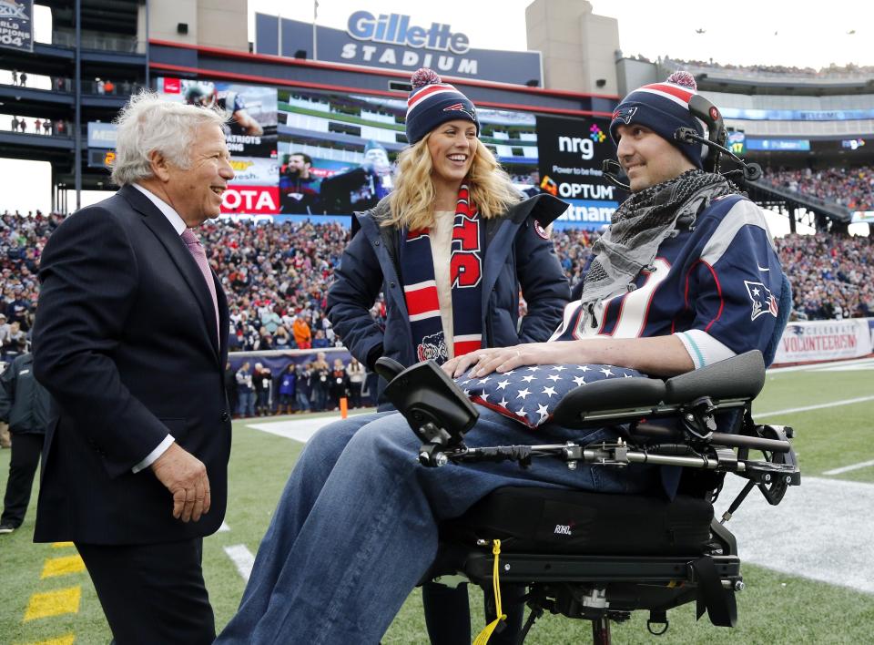 FILE - In this Dec. 28, 2014, file photo, New England Patriots owner Robert Kraft, left, smiles with Pete Frates and his wife, Julie during a birthday ceremony for Pete during a break in an NFL football game between the Patriots and the Buffalo Bills in Foxborough, Mass. Frates, a former college baseball player whose determined battle with Lou Gehrig’s disease helped inspire the ALS ice bucket challenge that has raised more than $200 million worldwide, died Monday, Dec. 9, 2019. He was 34. (AP Photo/Elise Amendola, File)