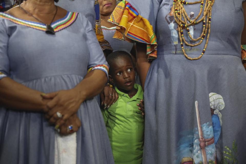 FILE - A child stands with Vodou pilgrims during a Mass marking the feast day of agriculture and work, in Port-au-Prince, Haiti, May 1, 2024. Vodou was at the root of the revolution that led Haiti to become the world’s first free Black republic in 1804, a religion born in West Africa and brought across the Atlantic by enslaved people. (AP Photo/Odelyn Joseph, File)
