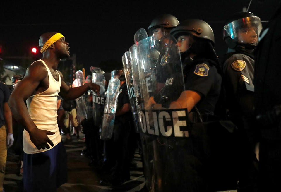 <p>A man yells at police in riot gear just before a crowd turned violent Saturday, Sept. 16, 2017, in University City, Mo. (Photo: Jeff Roberson/AP) </p>