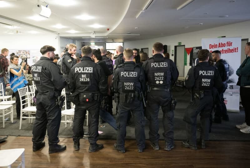 Police officers stand in the event room after the police broke up the first day of the Palestine Congress 2024. German police on Friday broke up a pro-Palestinian conference in the capital Berlin and asked some 250 participants to leave the venue just two hours into the three-day event. Officers had already intervened in the event during a speech via video by an activist who is banned from political activity in Germany. Sebastian Christoph Gollnow/dpa