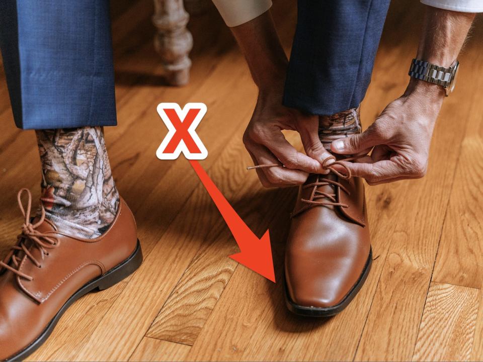 Man ties laces on square-toed dress shoes.