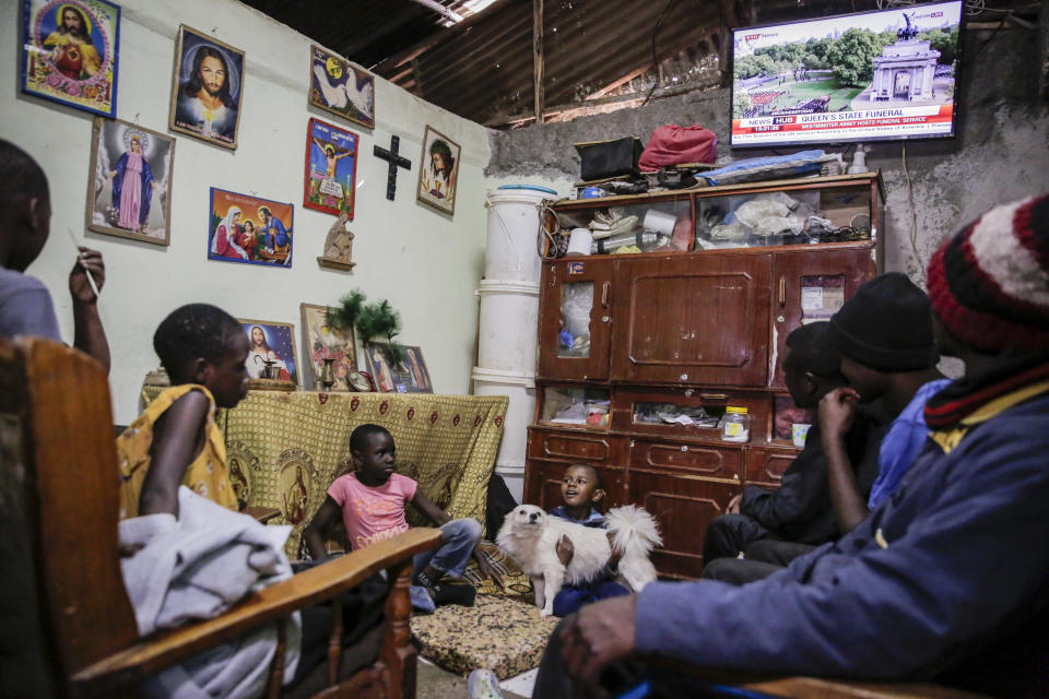 A family watches television coverage of the state funeral of Britain's Queen Elizabeth II, at their home in the low-income Kibera neighborhood of Nairobi, Kenya Monday, Sept. 19, 2022. The Queen, who died aged 96 on Sept. 8, will be buried at Windsor alongside her late husband, Prince Philip, who died last year. (AP Photo/Brian Inganga)