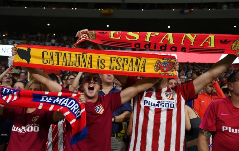 Atletico fans hold up their scarves before their Spanish league match against FC Barcelona at the Wanda Metropolitano stadium in Madrid on October 14, 2017