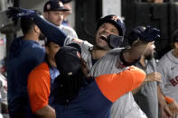 Houston Astros' Framber Valdez, left, picks up Jose Altuve in the dugout in celebration of Altuve's home run off Chicago White Sox starting pitcher Dylan Cease during the fifth inning of a baseball game Tuesday, Aug. 16, 2022, in Chicago. (AP Photo/Charles Rex Arbogast)