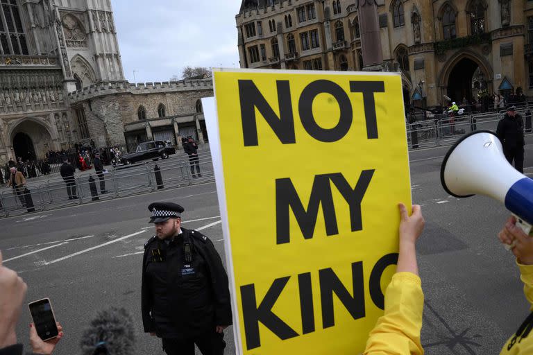 Manifestantes antimonárquicos protestan contra la familia real mientras el rey Carlos III de Gran Bretaña y Camilla, reina consorte británica, llegan a las afueras de la Abadía de Westminster en Londres el 13 de marzo de 2023.