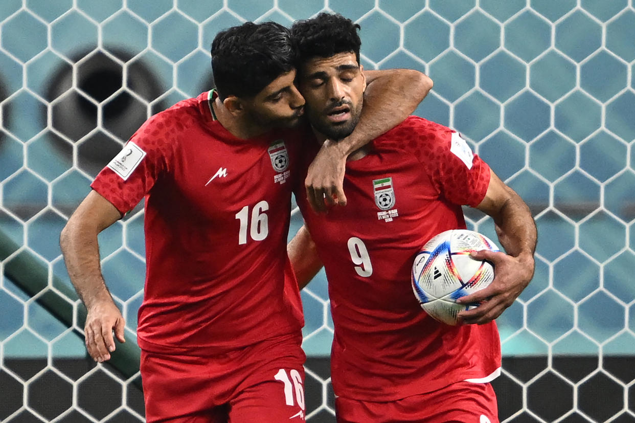 El jugador de Irán, Mehdi Taremi, celebra con Mehdi Torabitras tras anotar su primer gol en la Copa Mundial de Qatar 2022 frente a Inglaterra | Photo by PAUL ELLIS/AFP via Getty Images