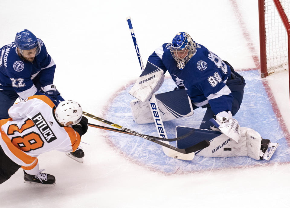 Philadelphia Flyers center Tyler Pitlick (18) gets hit by Tampa Bay Lightning defenseman Kevin Shattenkirk (22) as he shoots on goaltender Andrei Vasilevskiy (88) during the first period of an NHL hockey playoff game Saturday, Aug. 8, 2020, in Toronto. (Frank Gunn/The Canadian Press via AP)