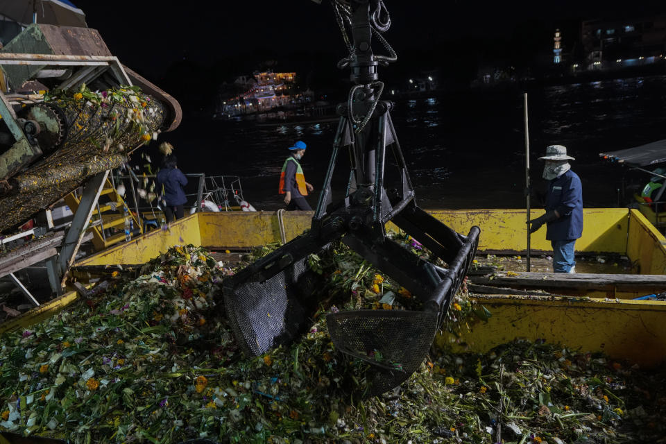 Worker collect small floating krathong from Chao Phraya River during Loy Krathong festival in Bangkok, Thailand, Friday, Nov. 19, 2021. As Thais flocked to waterways Friday to release small floats adorned with flowers and candles in an annual festival honoring the goddess of rivers, they also pile trash that clogs drains and canals and pollutes the country's rivers. (AP Photo/Sakchai Lalit)