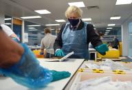 Britain's Prime Minister Boris Johnson (R) wears PPE (Personal Protective Equipment) as he visits the Lighthouse Laboratory used for processing PCR samples at the Queen Elizabeth University Hospital campus in Glasgow, Scotland on January 28, 2021, during a COVID-19 related visit to the country. - Prime Minister Boris Johnson headed to Scotland on Thursday to praise the United Kingdom's collective response to coronavirus, in a bid to counter record support for independence. (Photo by Jeff J Mitchell / POOL / AFP) (Photo by JEFF J MITCHELL/POOL/AFP via Getty Images)