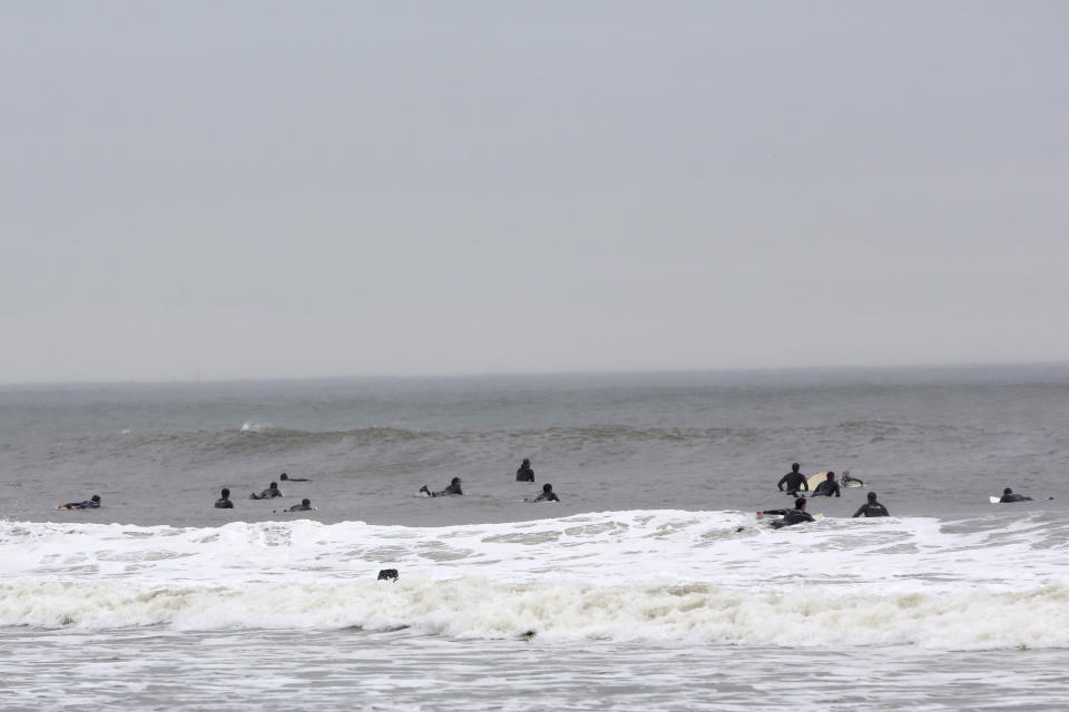 FILE - In this file photo of May 24, 2013 photo, surfers wait to catch waves at Rockaway Beach in the Queens borough of New York. Superstorm Sandy hit the Rockaways hard last fall, flooding homes and stores, eroding the beach in some spots and destroying the boardwalk, but subway service has been restored, small businesses are reopening, and the beaches are attracting plenty of visitors. (AP Photo/Mary Altaffer, File)