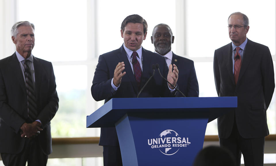 Florida Gov. Ron DeSantis speaks, as from left, Tom Williams, Chairman & CEO Universal Parks & Resorts; Orange County Mayor Jerry Demings; and Brian L. Roberts, Chairman & CEO Comcast Corporation, listen during a press conference at the Orange county Convention Center in Orlando, Fla., Thursday, Aug. 1, 2019. Universal Orlando officials announced that the resort is doubling in size with plans for a fourth theme park. (Ricardo Ramirez Buxeda/Orlando Sentinel via AP)