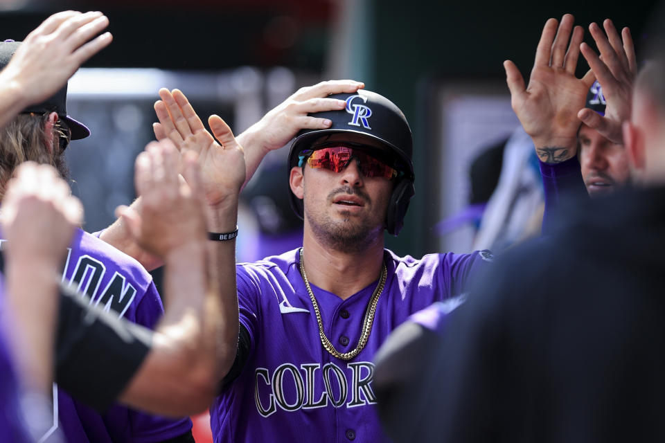 Colorado Rockies' Joshua Fuentes celebrates with teammates after scoring a run during the second inning of a baseball game against the Cincinnati Reds in Cincinnati, Saturday, June 12, 2021. (AP Photo/Aaron Doster)