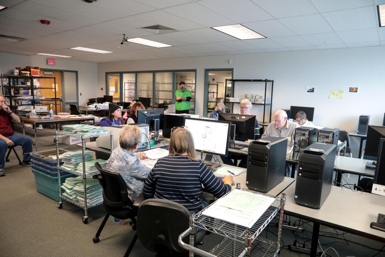 Workers manually resolve issues on ballots at the Marion County Election office on Nov. 3.