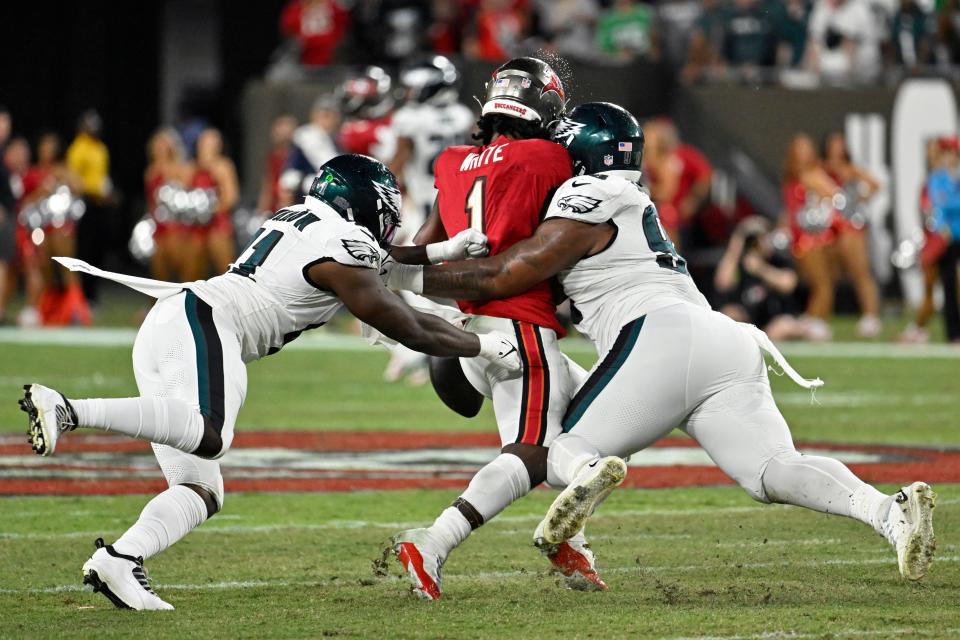 Tampa Bay Buccaneers' Rachaad White (1) fumbles as he is tackled by Philadelphia Eagles' Jalen Carter (98) and Sydney Brown (21) during the first half of an NFL football game, Monday, Sept. 25, 2023, in Tampa, Fla.