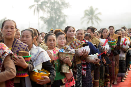 Women line up for alms offering as they take part in an elephant festival, which organisers say aims to raise awareness about elephants, in Sayaboury province, Laos February 17, 2017. REUTERS/Phoonsab Thevongsa