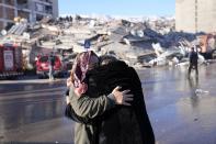 Two women hug each other in front of a destroyed building in Kahramanmaras, southern Turkey, Wednesday, Feb. 8, 2023. With the hope of finding survivors fading, stretched rescue teams in Turkey and Syria searched Wednesday for signs of life in the rubble of thousands of buildings toppled by a catastrophic earthquake. (AP Photo/Hussein Malla)