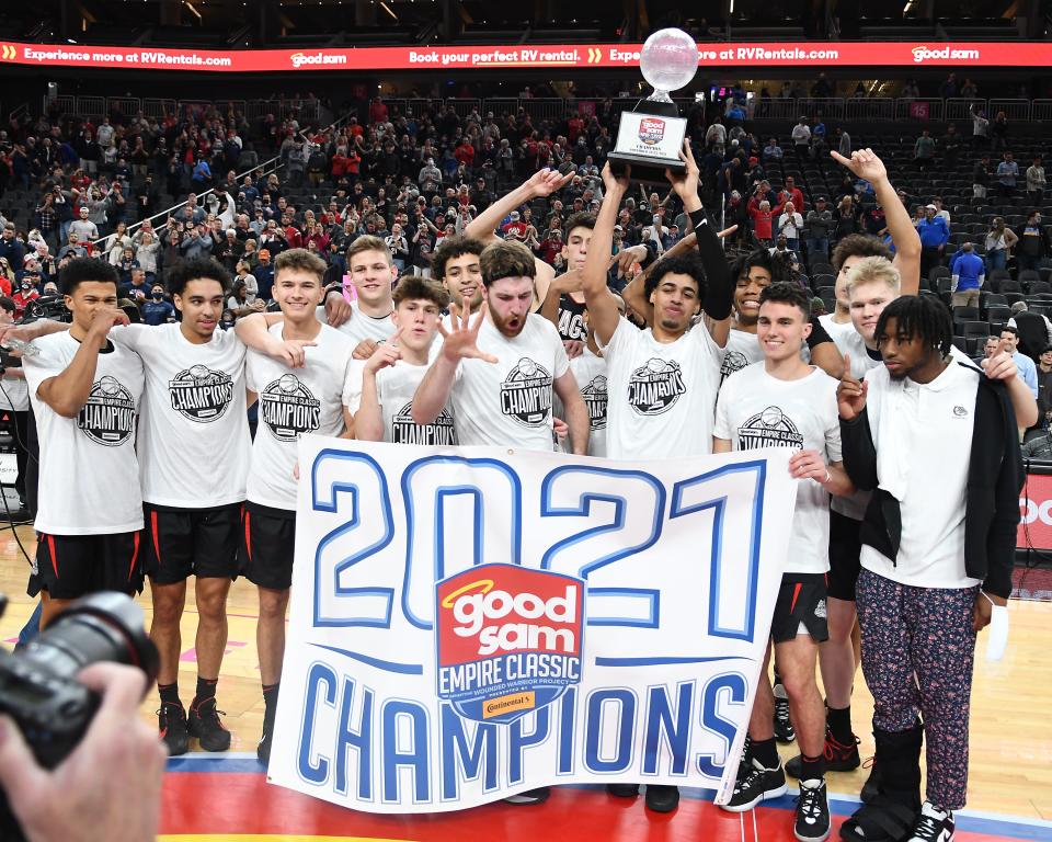 The Gonzaga Bulldogs players celebrate with the Good Sam Empire Classic championship trophy after defeating the UCLA Bruins 83-63 at T-Mobile Arena.