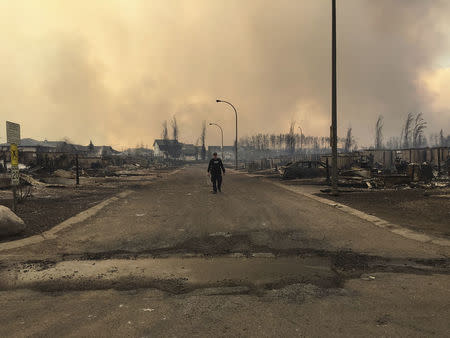 A Mountie surveys the damage on a street in Fort McMurray, Alberta, Canada, May 4, 2016. Courtesy Alberta RCMP/Handout via REUTERS