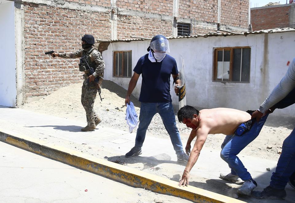 Security forces detain a supporter of ousted Peruvian President Pedro Castillo, on the Pan-American North Highway in Chao, Peru, Thursday, Dec. 15, 2022. Peru's new government declared a 30-day national emergency on Wednesday amid violent protests following Castillo's ouster, suspending the rights of "personal security and freedom" across the Andean nation. (AP Photo/Hugo Curotto)