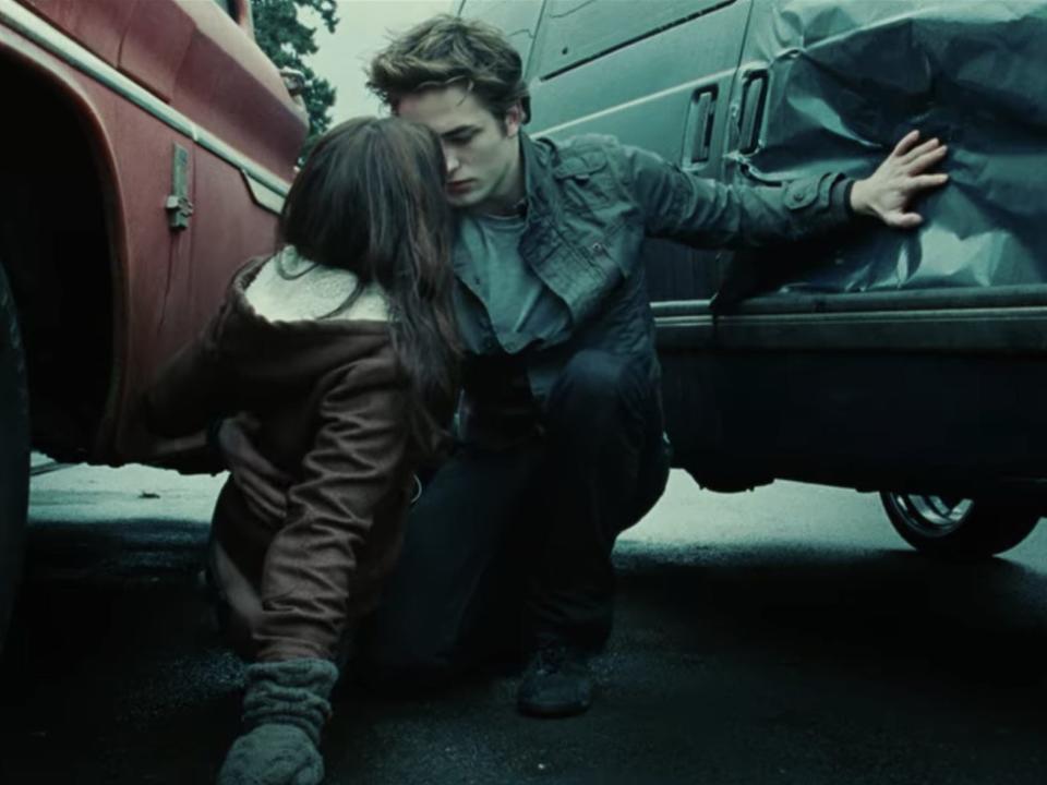 Edward (Robert Pattinson) stops a car from hitting Bella (Kristen Stewart) in a scene from "Twilight."