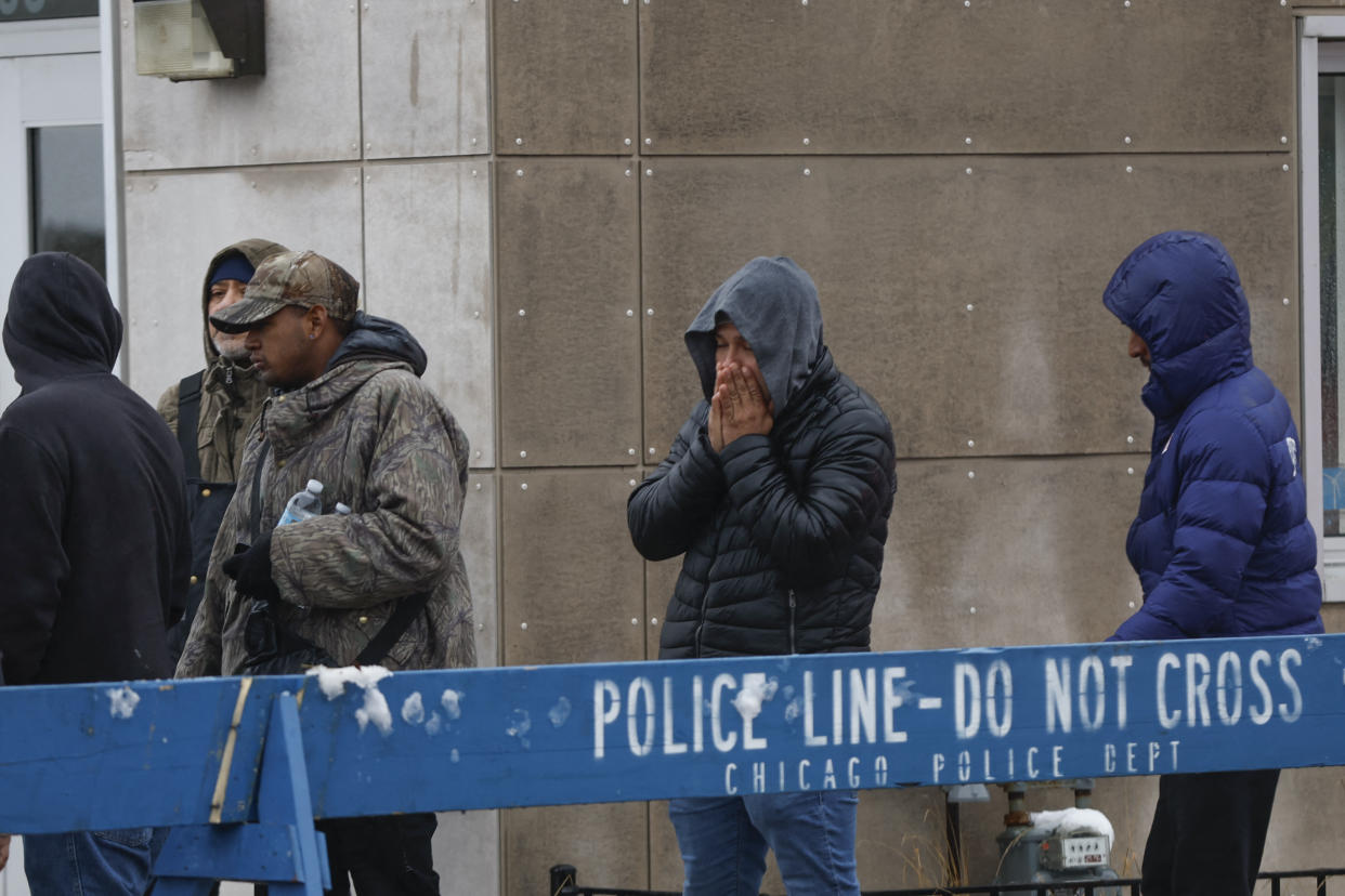 A group of migrants wait outside in line to receive food in Chicago.