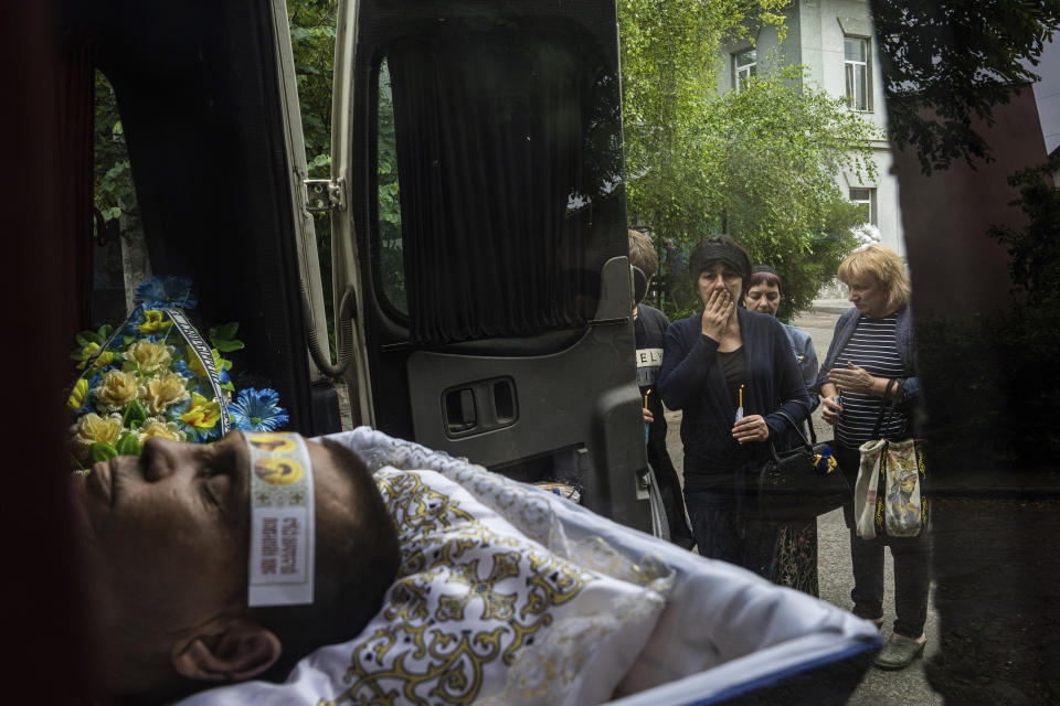 Svitlana Nosik, de 56 años, mira a su hermano, Vitali Holodniak, de 46, durante su entierro en Jersón, Ucrania, el 14 de junio de 2023. Según las autoridades ucranianas, Holodniak fue asesinado por rusos en Kardashynka, durante una operación para evacuar a residentes de la inundada localidad cerca de Jersón. (AP Foto/Evgeniy Maloletka)