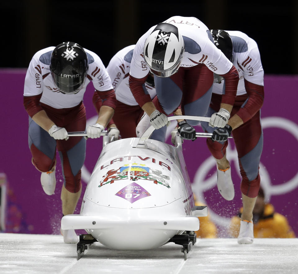 The team from Latvia LAT-1, with Oskars Melbardis, Daumants Dreiskens, Arvis Vilkaste and Janis Strenga, start their first run during the men's four-man bobsled competition at the 2014 Winter Olympics, Saturday, Feb. 22, 2014, in Krasnaya Polyana, Russia. (AP Photo/Natacha Pisarenko)