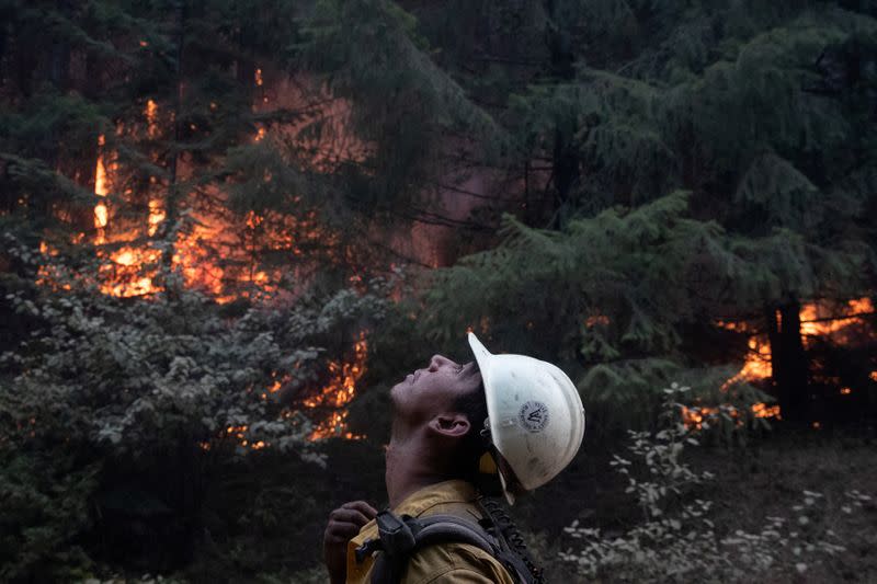 FILE PHOTO: Firefighter monitors ambers from a firing operation near the Obenchain Fire in Butte Falls, Oregon