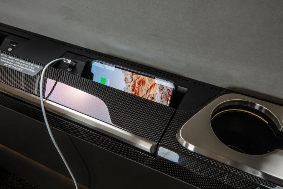 An iphone charging in the M2 with a cupholder and USB in view.