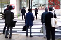 People stand near an electronic stock board showing Japan's Nikkei 225 index at a securities firm Wednesday, March 27, 2024, in Tokyo. Asian shares were mixed on Wednesday after Wall Street slipped a bit further from its record highs. (AP Photo/Eugene Hoshiko)