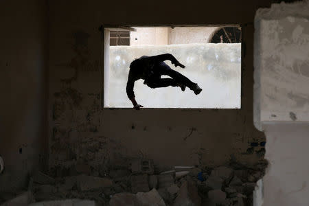 Parkour coach Ibrahim al-Kadiri, 19, demonstrates his parkour skills amid damage in the rebel-held city of Inkhil, west of Deraa, Syria, February 4, 2017. Led by Ibrahim, the team trains on quiet days. REUTERS/Alaa Al-Faqir