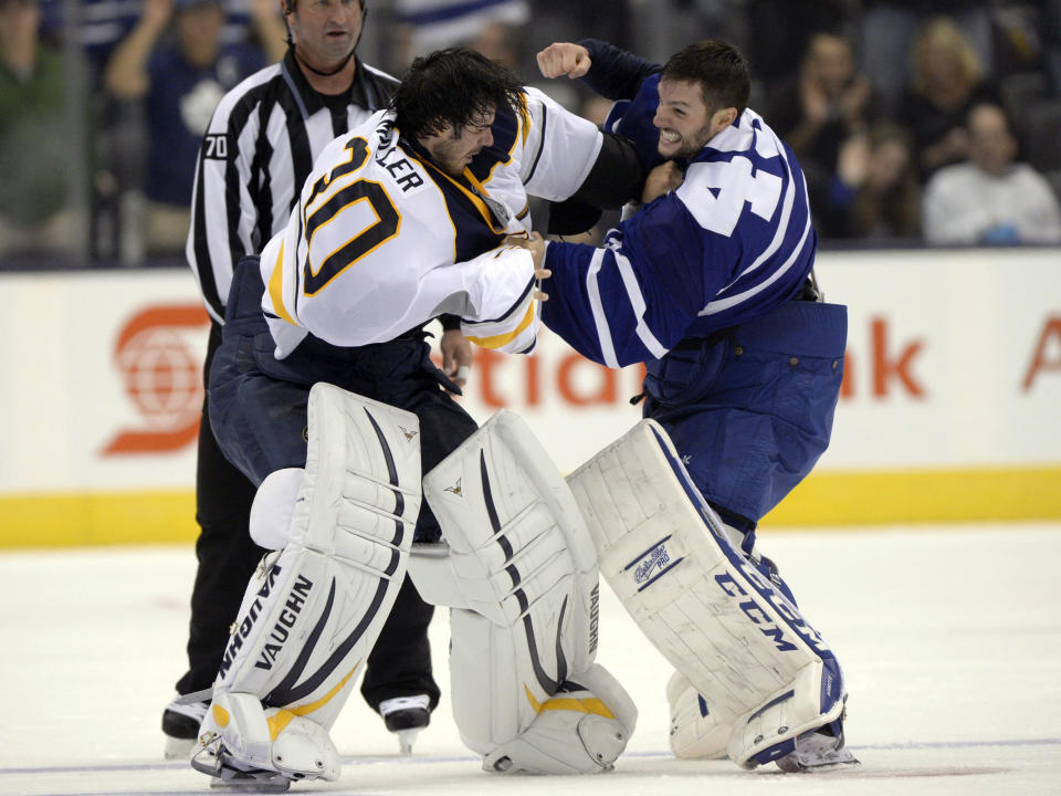 FILE - Buffalo Sabres goalie Ryan Miller, front left, fights with Toronto Maple Leafs goalie Jonathan Bernier, right, during the third period of an NHL hockey preseason game in Toronto, Sept. 22, 2013. The league rule changes have made it so punitive that goalie fighting has essentially disappeared from the highest level of hockey. (AP Photo/The Canadian Press, Frank Gunn, File)