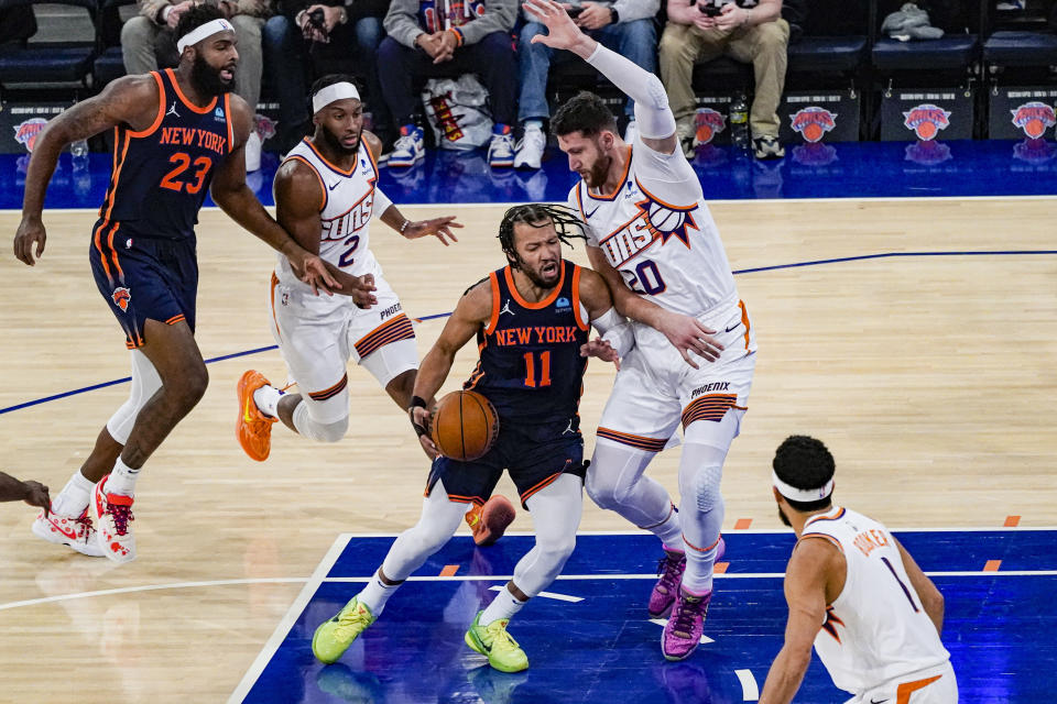 New York Knicks guard Jalen Brunson (11) fights through contact from Phoenix Suns center Jusuf Nurkic (20) during the first half of an NBA basketball game in New York, Sunday, Nov. 26, 2023. (AP Photo/Peter K. Afriyie)