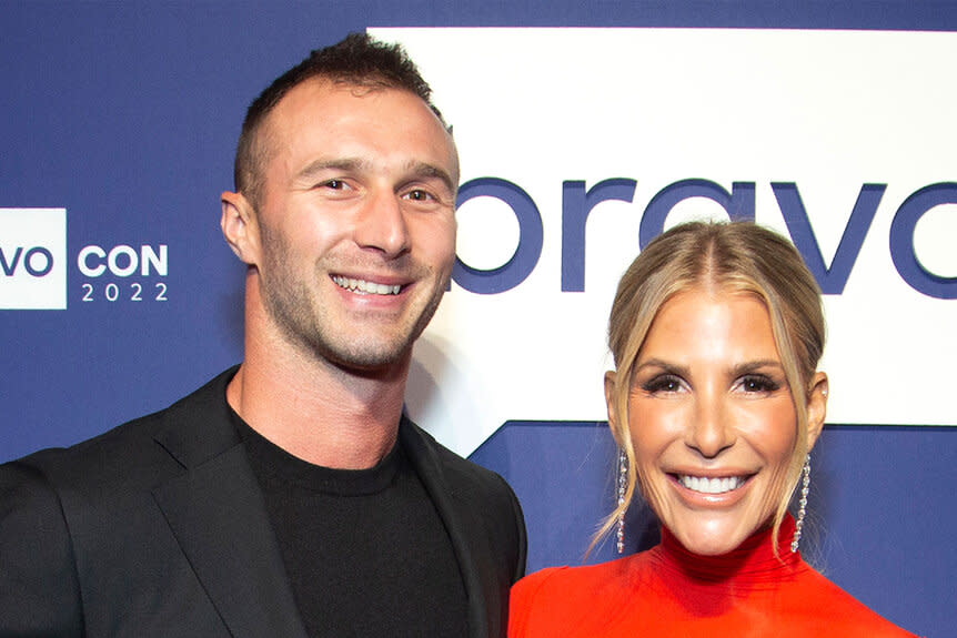 Tracy and Erik smiling together in front of a step and repeat.