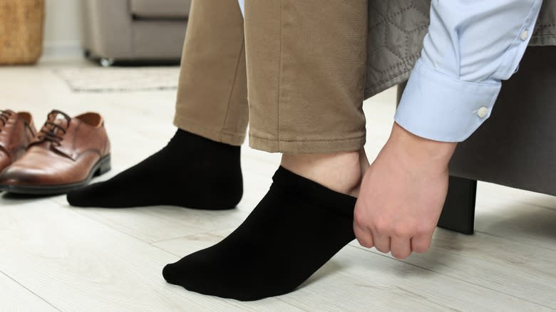 Man putting on black socks