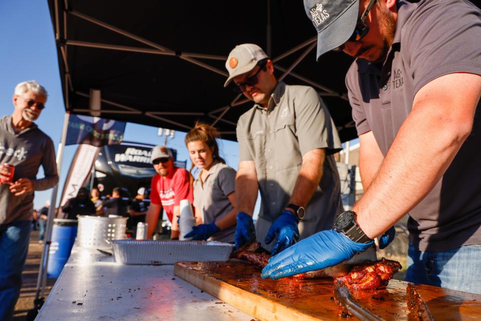 Workers at the Ag Texas booth serve ribs to attendees during the Hub City BBQ Cookoff on Thursday, Oct. 14, 2021 at the South Plains Fairgrounds in Lubbock, Texas.