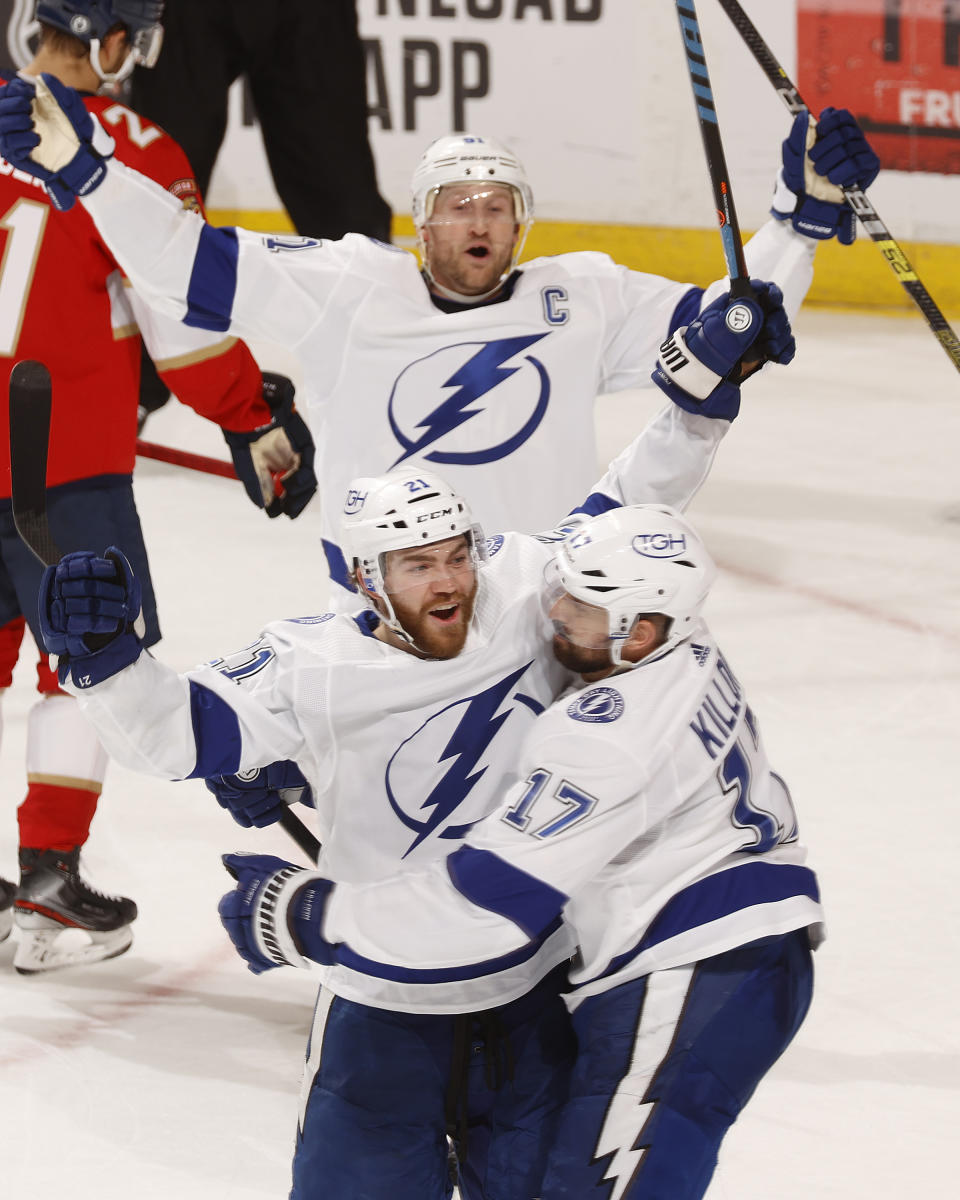 Tampa Bay Lightning center Steven Stamkos (91) and left wing Alex Killorn (17) celebrate the game-tying goal by defenseman Brayden Point (21) during the third period in Game 1 of an NHL hockey Stanley Cup first-round playoff series against the Florida Panthers, Sunday, May 16, 2021, in Sunrise, Fla. (AP Photo/Joel Auerbach)