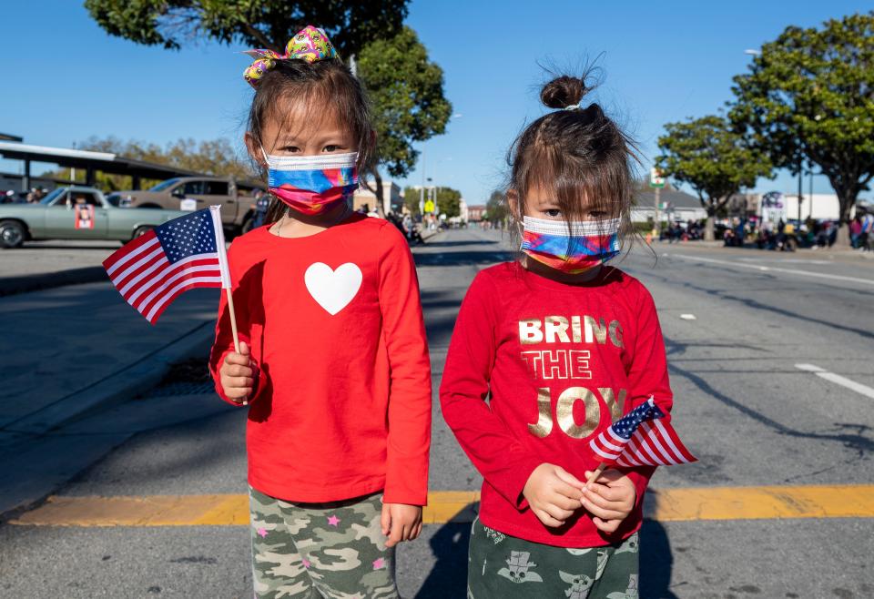 Two young children are photographed each holding an American flag during the 11th Annual Veteran's Day Parade in Salinas, Calif., on Thursday, Nov. 11, 2021.