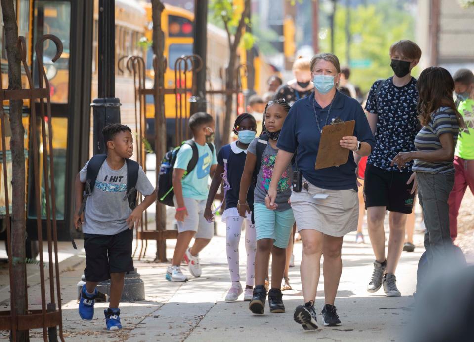 Teacher Erin Bailey walks students to their buses they're released early due to extreme heat at Golda Meir School in Milwaukee on Aug. 25.