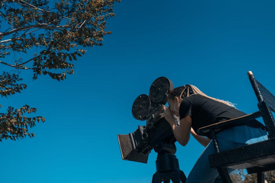 Mujer manejando una cámara de cine.