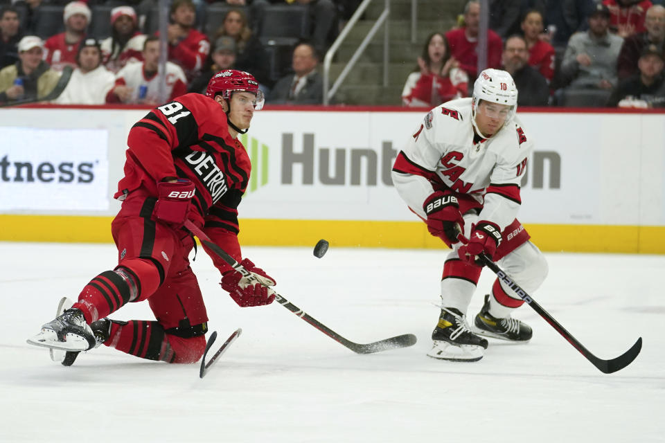 Carolina Hurricanes center Jack Drury (18) defends Detroit Red Wings left wing Dominik Kubalik (81) in the second period of an NHL hockey game Tuesday, Dec. 13, 2022, in Detroit. (AP Photo/Paul Sancya)