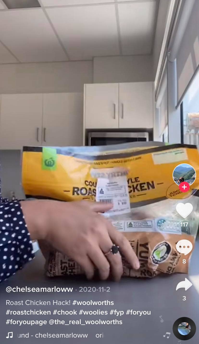 Still from a TikTok showing hands holding a bagged hot chicken. Source: TikTok/@chelseamarloww