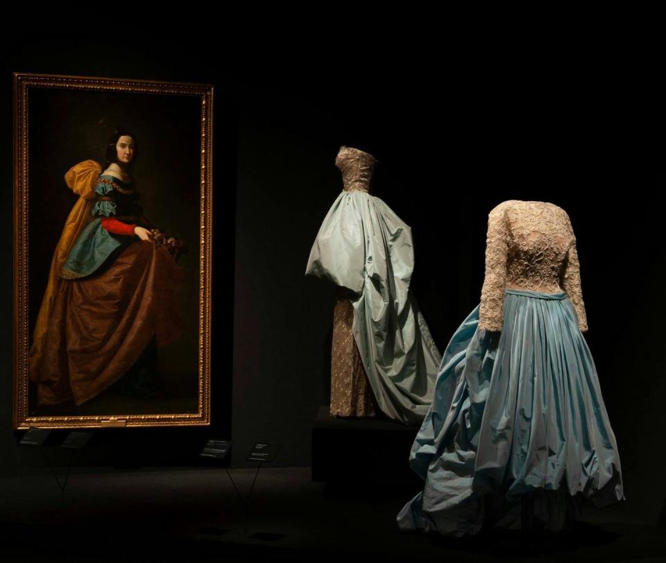 Conjunto de noche de vestido de tul de algodón bordado con hilo metálico sobre raso de rayón y sobrefalda de tafetán de seda de Balenciaga y _Santa Isabel de Portugal_ de Francisco de Zurbarán.