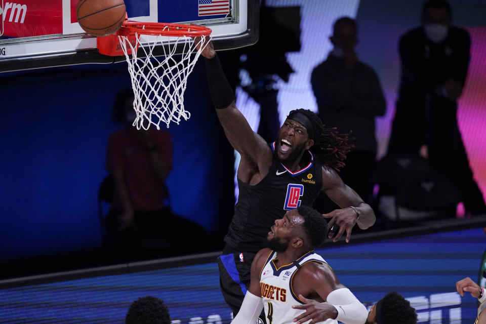 Los Angeles Clippers forward Montrezl Harrell (5) drives to the basket over Denver Nuggets forward Paul Millsap (4) during the first half of an NBA conference semifinal playoff basketball game Tuesday, Sept. 15, 2020, in Lake Buena Vista, Fla. (AP Photo/Mark J. Terrill)
