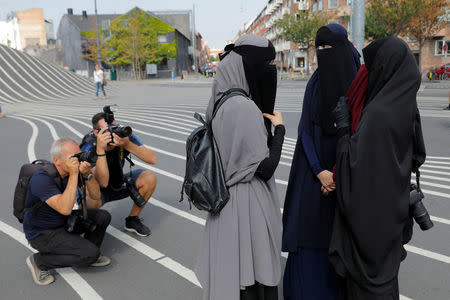 Members of the media photograph women in niqabs before a demonstration against the Danish face veil ban in Copenhagen, Denmark, August 1, 2018. REUTERS/Andrew Kelly