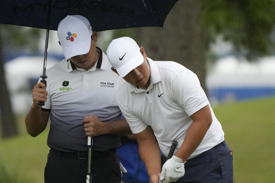 Si Woo Kim, left, and his teammate Tom Kim, both of South Korea, survey their shot on the sixth green during the second round of the PGA Zurich Classic golf tournament at TPC Louisiana in Avondale, La., Friday, April 21, 2023. (AP Photo/Gerald Herbert)